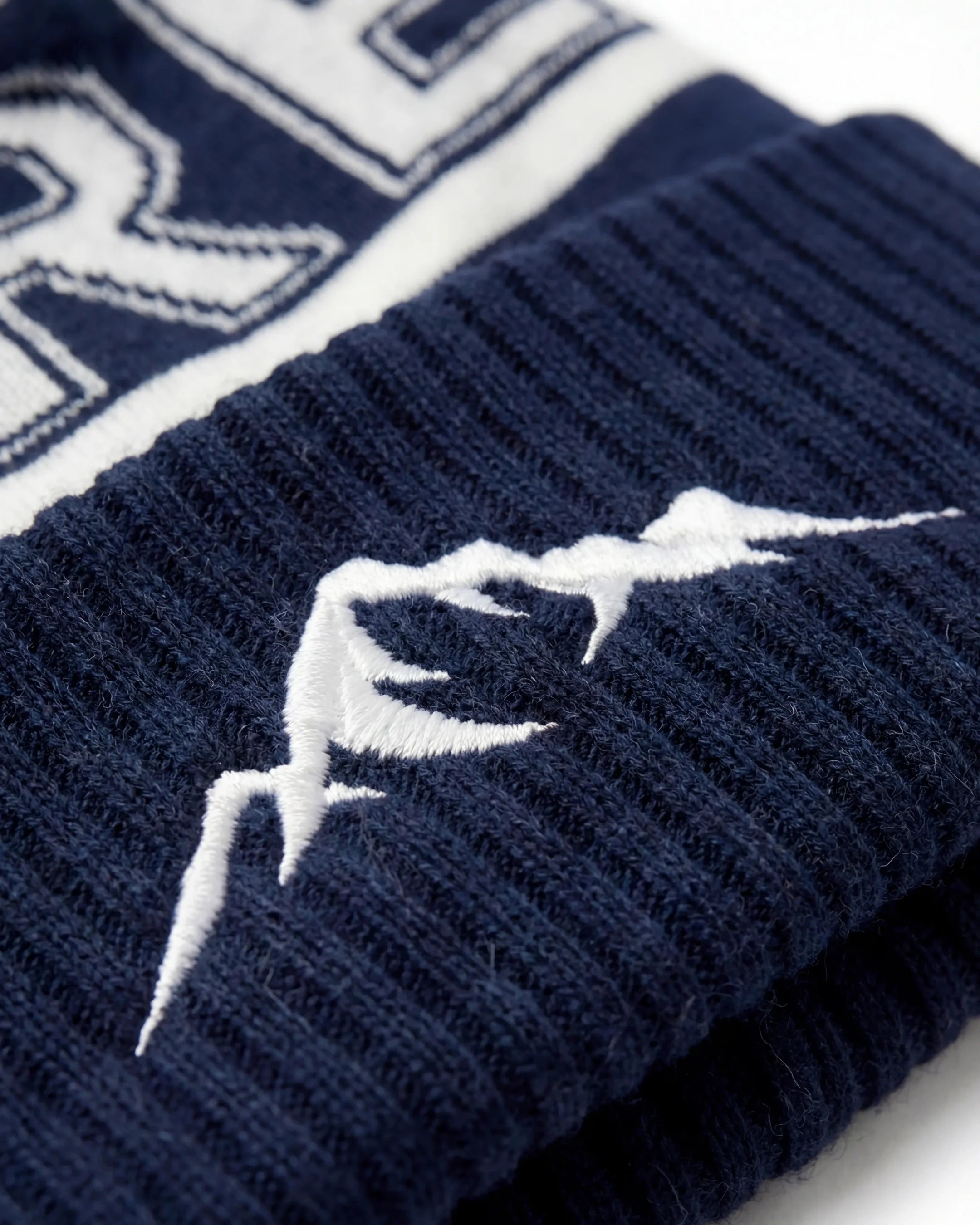 Marinblå Åre Mössa med Tofs - Närbild på logotyp