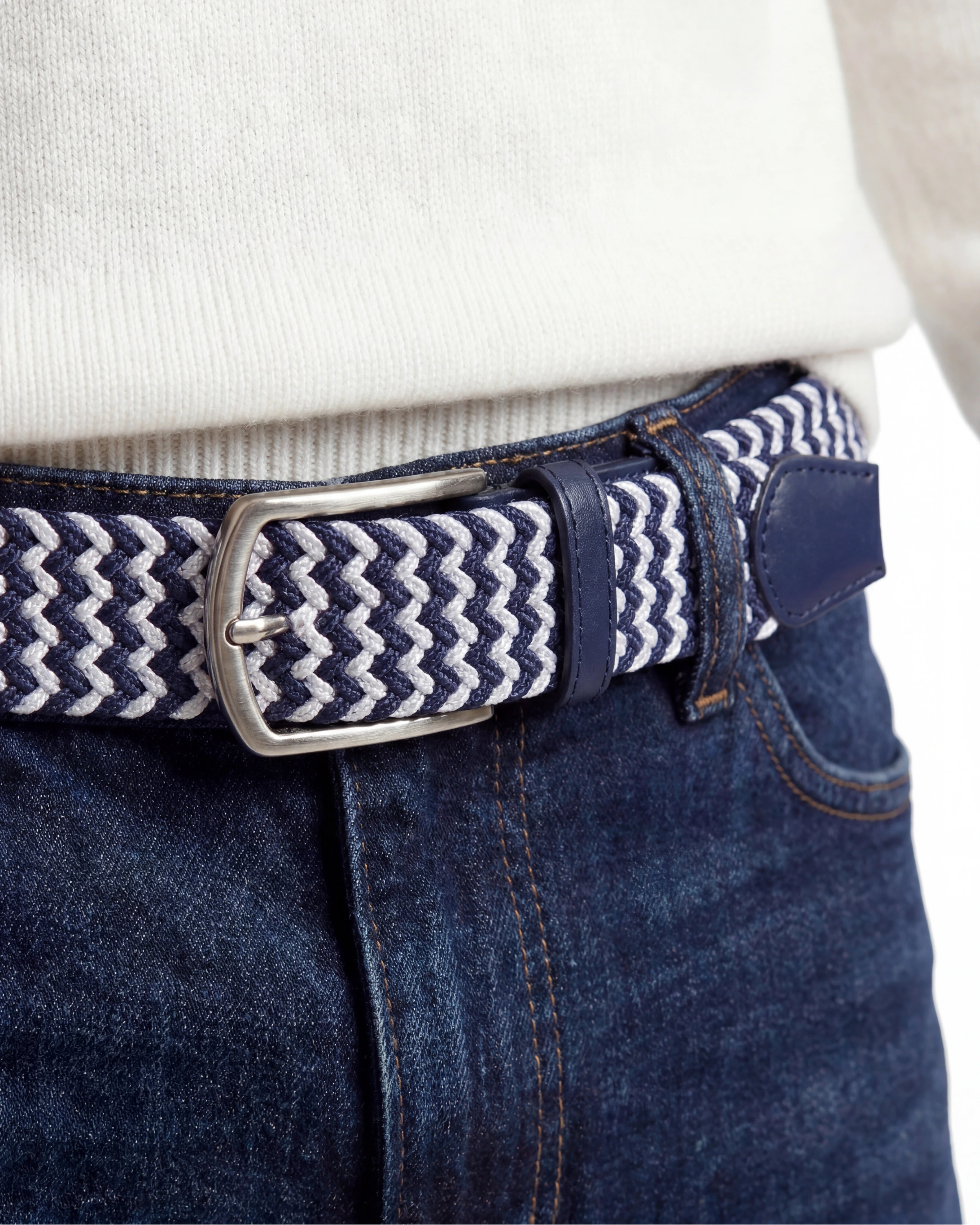 Detaljbild på flätat bälte marinblå & vit tillsammans med jeans